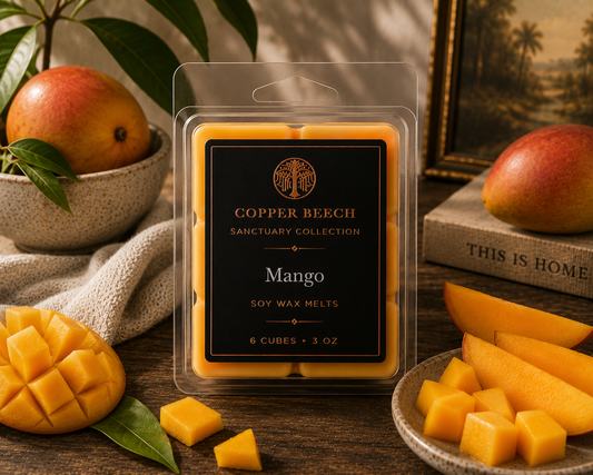 Copper Beech Mango soy wax melts surrounded by fresh mangoes in a warm, nature-inspired home setting.